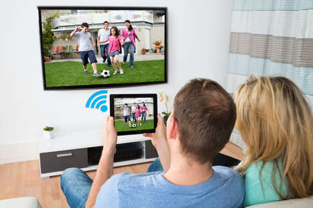 39653649-couple-connecting-television-and-digital-table-through-wifi-signal-at-home.jpg