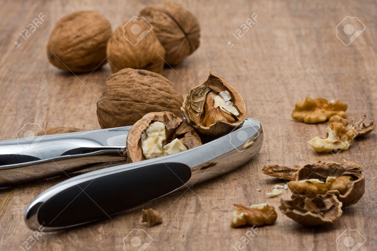 7544657-Cracking-walnuts-with-nutcracker-on-wooden-table-Stock-Photo.jpg