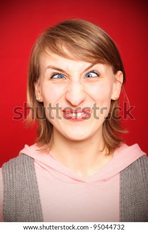 stock-photo-young-woman-grimacing-with-crossed-eyes-in-front-of-red-background-95044732.jpg
