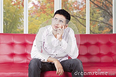 confused-man-sitting-couch-young-person-casual-clothes-sofa-home-thinking-something-57700436.jpg