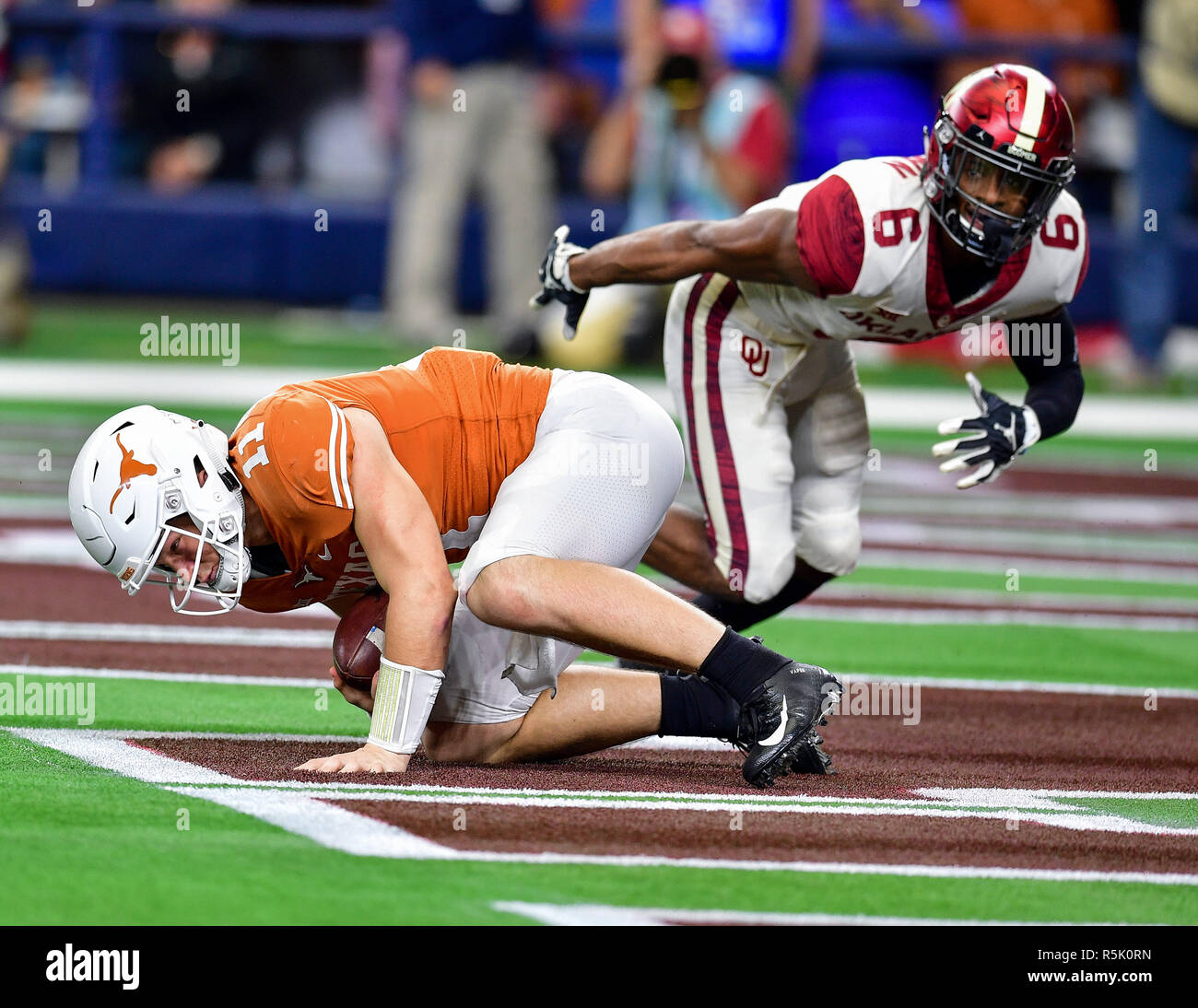 texas-longhorns-quarterback-sam-ehlinger-11-is-hit-hard-in-the-end-zone-for-a-safety-by-oklahoma-cornerback-tre-brown-6-during-the-dr-pepper-big-12-championship-between-the-oklahoma-sooners-vs-texas-longhorns-at-an-ncaa-big-12-championship-football-game-at-the-att-stadium-arlington-texas-120118manny-florescal-sport-media-R5K0RN.jpg