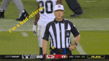 a referee stands on a football field with the words  i 'm a bad referee  on the screen behind him