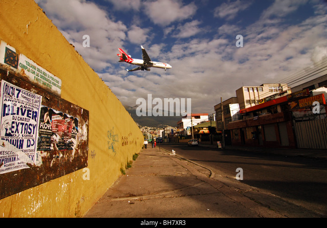 ecuador-quito-red-and-white-plane-flying-low-over-the-city-in-preparation-bh7xr3.jpg