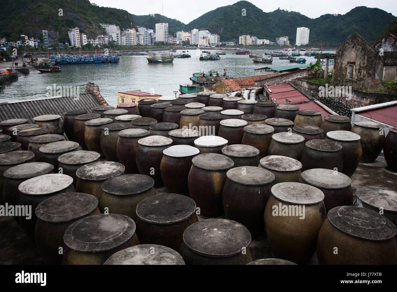 barrels-of-fermenting-fish-used-for-sauce-in-the-foreground-cat-ba-J77XTB.jpg