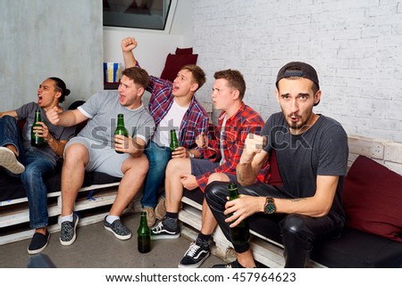 stock-photo-friends-together-watching-tv-drinking-beer-yelling-laughing-having-fun-young-fans-in-the-room-457964623.jpg