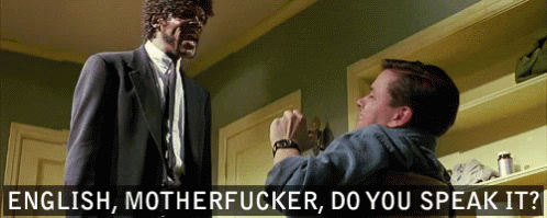 a man in a suit and tie is talking to another man in a chair with the words english motherfucker do you speak it behind them