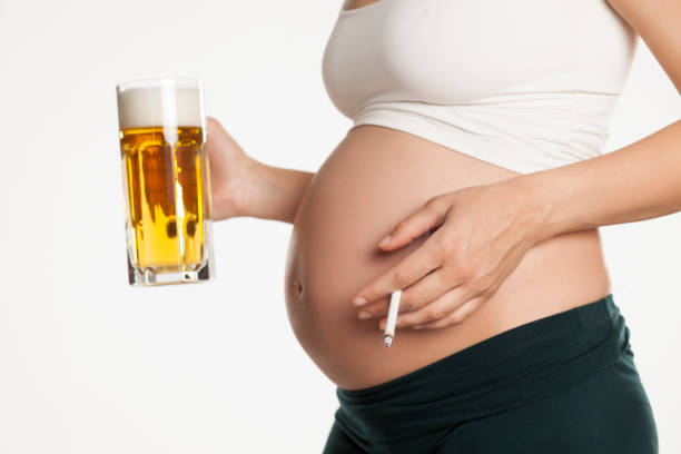 young-pregnant-woman-with-a-mug-of-beer-and-a-cigarette-in-her-hands-picture-id962119632