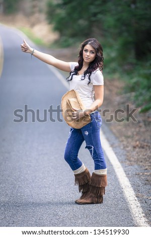 stock-photo-teen-girl-hitchhiking-with-cowboy-hat-134519930.jpg